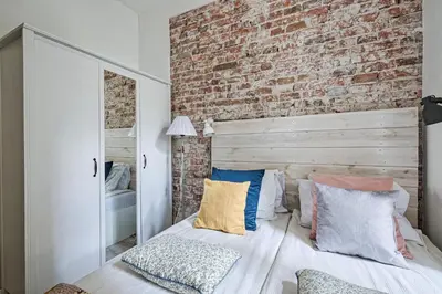 a bedroom with a brick wall and a bed with pillows at Urban Nest Apartments Blich 8 in Kraków