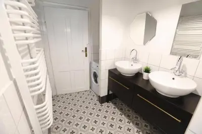 a bathroom with two sinks and a mirror at Urban Nest Apartments Blich 8 in Kraków