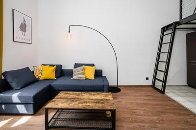 a living room with a blue couch and a coffee table at Dajwor Residence Jewish Quarter WAWELOFTS in Kraków