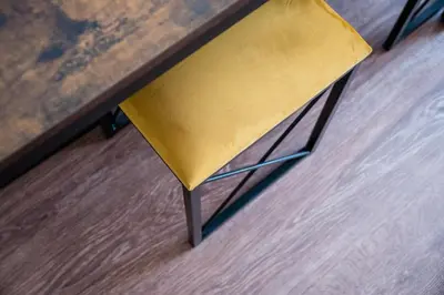 a yellow chair sitting next to a wooden table at Dajwor Residence Jewish Quarter WAWELOFTS in Kraków