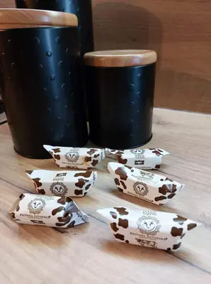 a group ofpaper cows on a table next to a cup at Silver 58 Zator in Zator