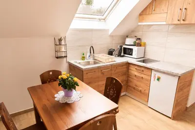 a kitchen with a wooden table with a vase of flowers on it at Apartamenty Home&Spa in Rabka