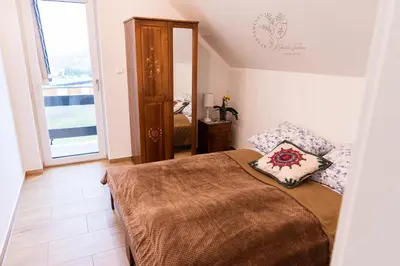 a bedroom with a bed and a large window at Apartamenty Home&Spa in Rabka