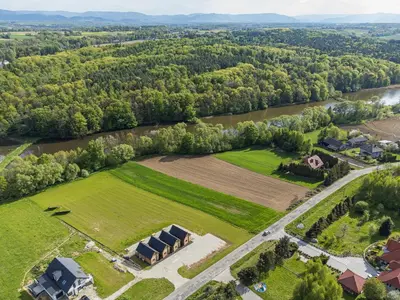 an aerial view of a farm with a house and a river at Wycisznia - drewniane domki całoroczne in Gierałtowiczki