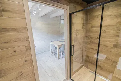 a sauna with a glass door leading to a table at Wycisznia - drewniane domki całoroczne in Gierałtowiczki