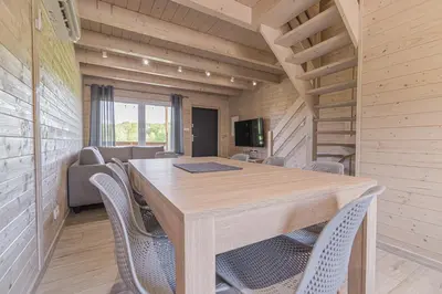 a dining room with a table and chairs at Wycisznia - drewniane domki całoroczne in Gierałtowiczki