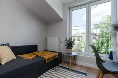 a living room with a black couch and a window at Smart Apartments - Old Town & Main Train Station - by Upstairs in Kraków