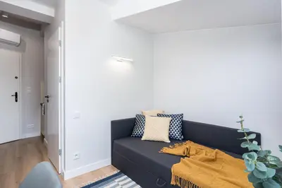 a living room with a black couch with a yellow blanket at Smart Apartments - Old Town & Main Train Station - by Upstairs in Kraków