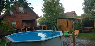 a swimming pool in front of a house at Szyszka i Róża Domek na Jurze in Zelasko