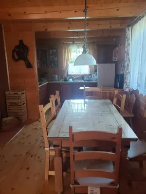 a dining room with a wooden table and chairs at Szyszka i Róża Domek na Jurze in Zelasko