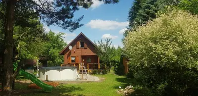 a small house with a playground in the yard at Szyszka i Róża Domek na Jurze in Zelasko