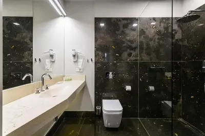 a bathroom with a toilet and a glass shower at Dada Premium Aparthotel in Kraków