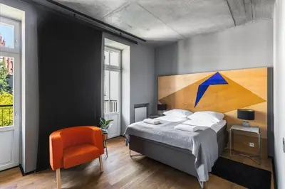 a bedroom with a bed with a painting on the wall at Dada Premium Aparthotel in Kraków