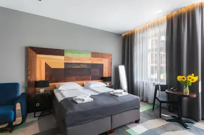 a hotel room with a bed and a window at Dada Premium Aparthotel in Kraków