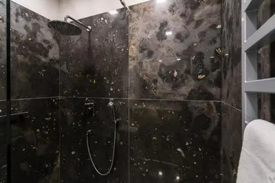 a bathroom with a shower with a glass wall at Dada Premium Aparthotel in Kraków