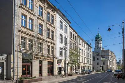 a row of buildings on a street with a clock tower at Dada Premium Aparthotel in Kraków