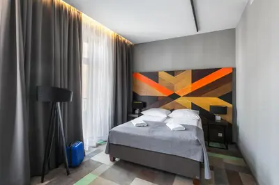 a bedroom with a bed with a painting on the wall at Dada Premium Aparthotel in Kraków