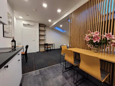 a kitchen and dining room with a table and flowers at Dada Premium Aparthotel in Kraków