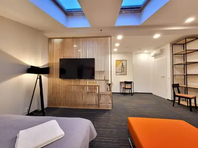 a room with a bed and a flat screen tv at Dada Premium Aparthotel in Kraków