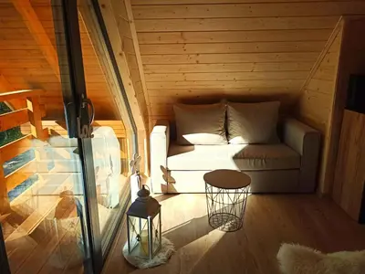 a small room with a couch and a table at Las Lorien - wynajem domków letniskowych in Roczyny
