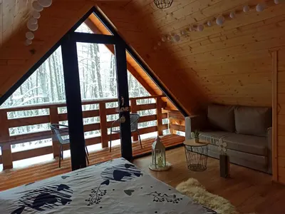 a room with a bed and a couch in a cabin at Las Lorien - wynajem domków letniskowych in Roczyny