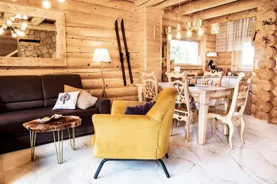 a living room with a couch and a table and chairs at Pyrgielówka- chata Roztoki in Stryszawa