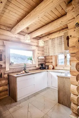 a kitchen with wooden walls and a large window at Pyrgielówka- chata Roztoki in Stryszawa