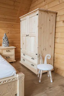 a bedroom with a bed and a cabinet and a chair at Pyrgielówka- chata Roztoki in Stryszawa