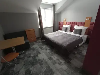 a bedroom with a bed and a desk and a window at Agroturystyka AMiG in Krzywopłoty