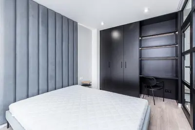 a bedroom with a large white bed and black cabinets at Apartments Browar Kleparz by Noclegi Renters in Kraków