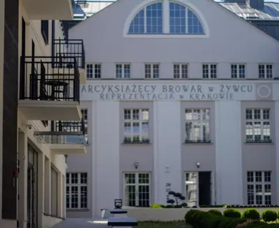 a white building with a sign on it at Apartments Browar Kleparz by Noclegi Renters in Kraków