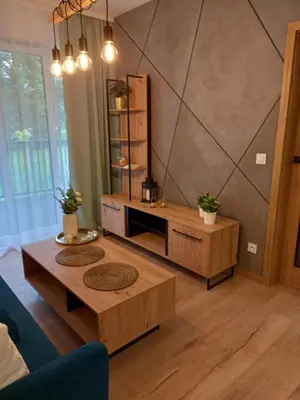 a living room with two tables and a wall at APARTAMENT PRESTIGE OŚWIĘCIM in Oświęcim