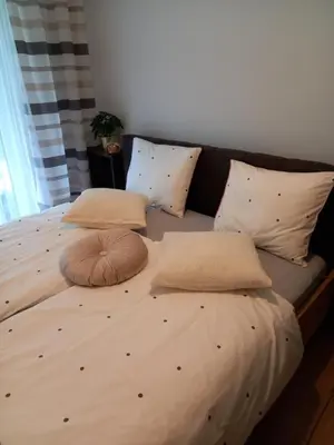 a large bed with two pillows on top of it at APARTAMENT PRESTIGE OŚWIĘCIM in Oświęcim