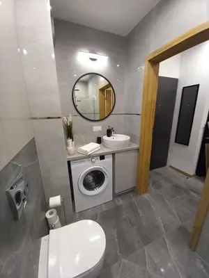 a bathroom with a washing machine and a sink at APARTAMENT PRESTIGE OŚWIĘCIM in Oświęcim