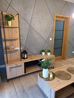 a room with wooden tables and shelves with potted plants at APARTAMENT PRESTIGE OŚWIĘCIM in Oświęcim