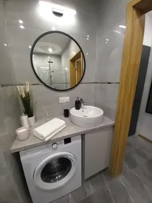 a bathroom with a washing machine and a sink at APARTAMENT PRESTIGE OŚWIĘCIM in Oświęcim