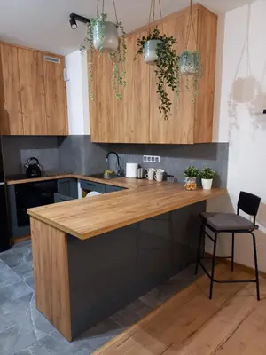 a kitchen with wooden cabinets and a counter top at APARTAMENT PRESTIGE OŚWIĘCIM in Oświęcim