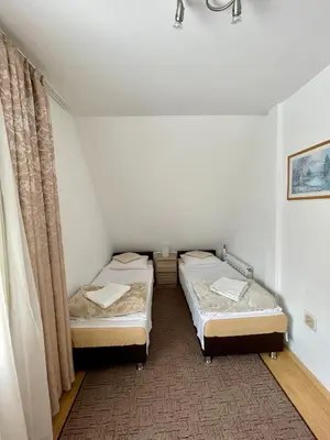 two beds in a small room with a window at Dom Wczasowy Anna in Rabka