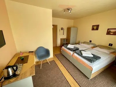 a bedroom with a bed and a desk and a chair at Dom Wczasowy Anna in Rabka