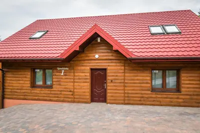 a wooden house with a red roof at Toffee House in Zator