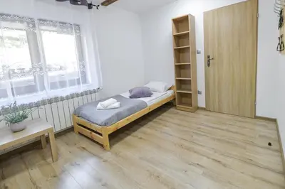 a small bedroom with a bed and a window at Toffee House in Zator