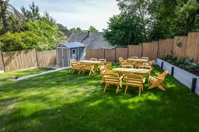 a group of tables and chairs in a yard at Toffee House in Zator