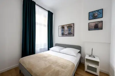 a bedroom with a bed and a large window at Native Apartments Paulińska 20 Superior in Kraków