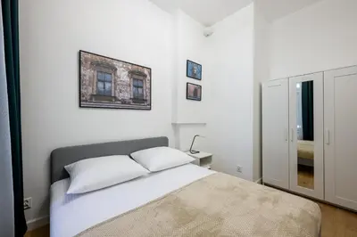 a white bedroom with a bed and a picture on the wall at Native Apartments Paulińska 20 Superior in Kraków
