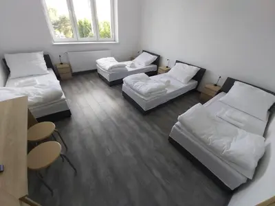 a room with three beds and a window at Apartamenty MARGO in Chrzanów