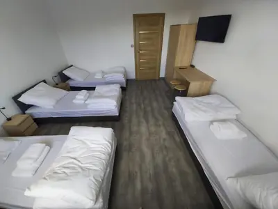 a room with three beds and a flat screen tv at Apartamenty MARGO in Chrzanów