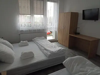 a bedroom with two beds and a television in it at Apartamenty MARGO in Chrzanów