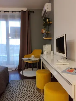 a room with a desk with a computer and yellow stools at JM Apartment Old Town Krakow in Kraków
