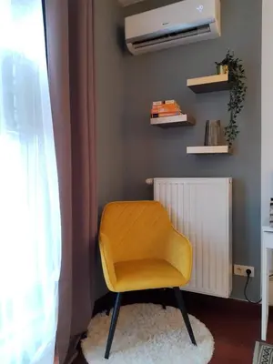 a yellow chair sitting in a room with a window at JM Apartment Old Town Krakow in Kraków