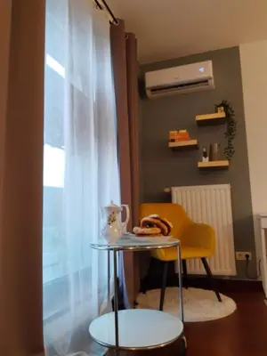 a table and a chair in a room with a window at JM Apartment Old Town Krakow in Kraków